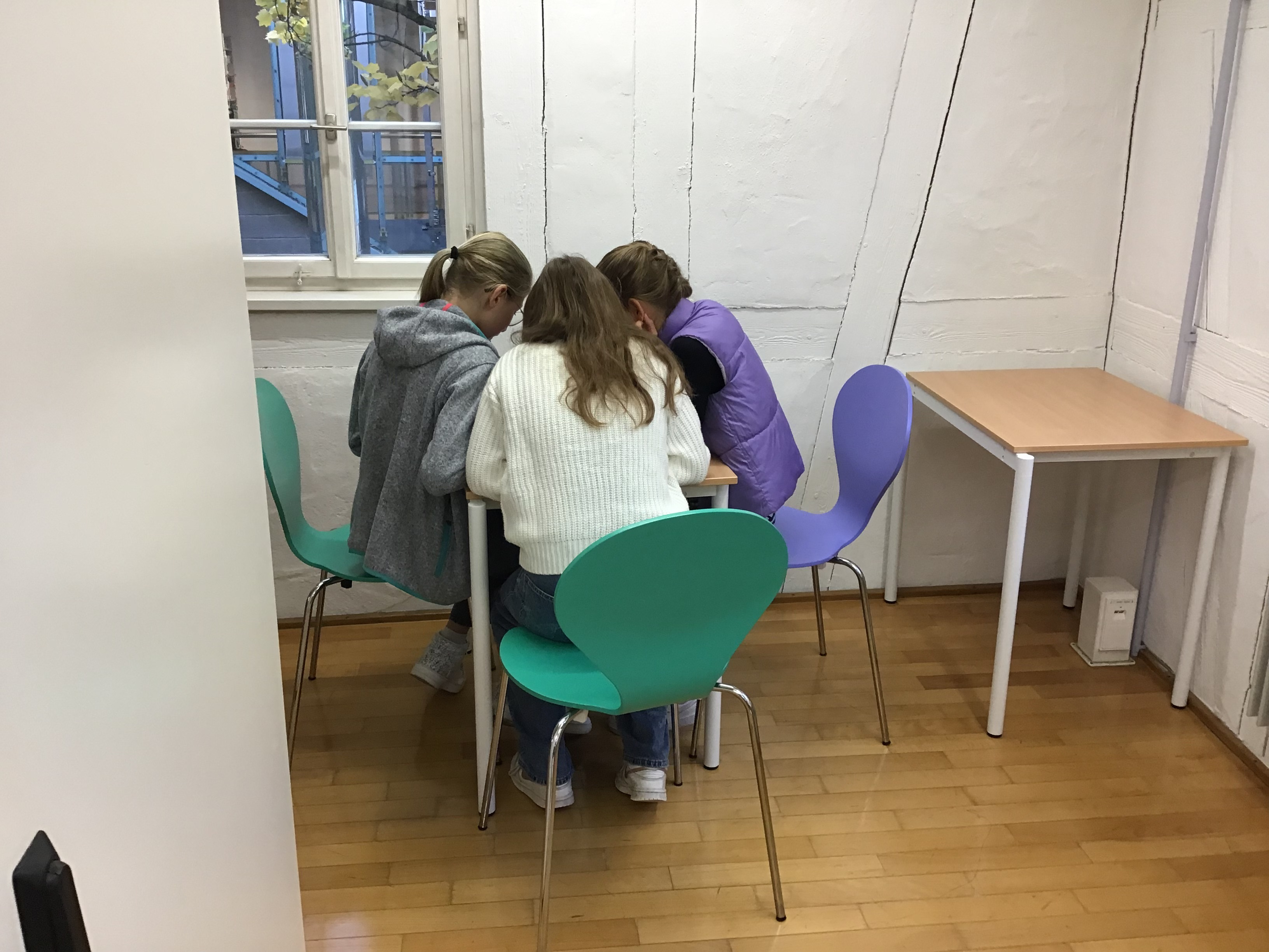 Eine Mädchengruppe sitzt vor dem iPad und prüft Apps