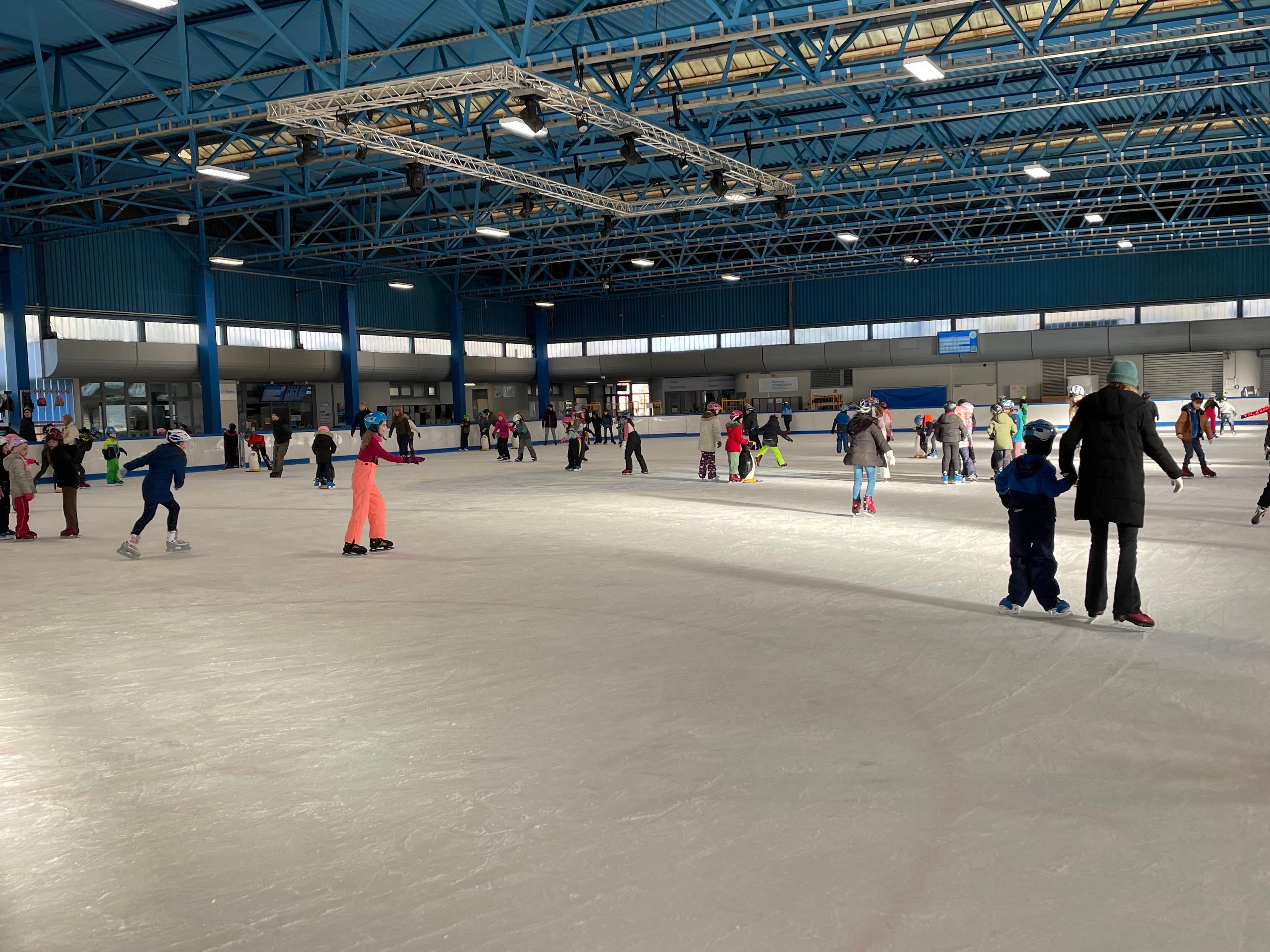 Bildbeschreibung: Kinder fahren Schlittschuh auf einer Eisfl&auml;che. 