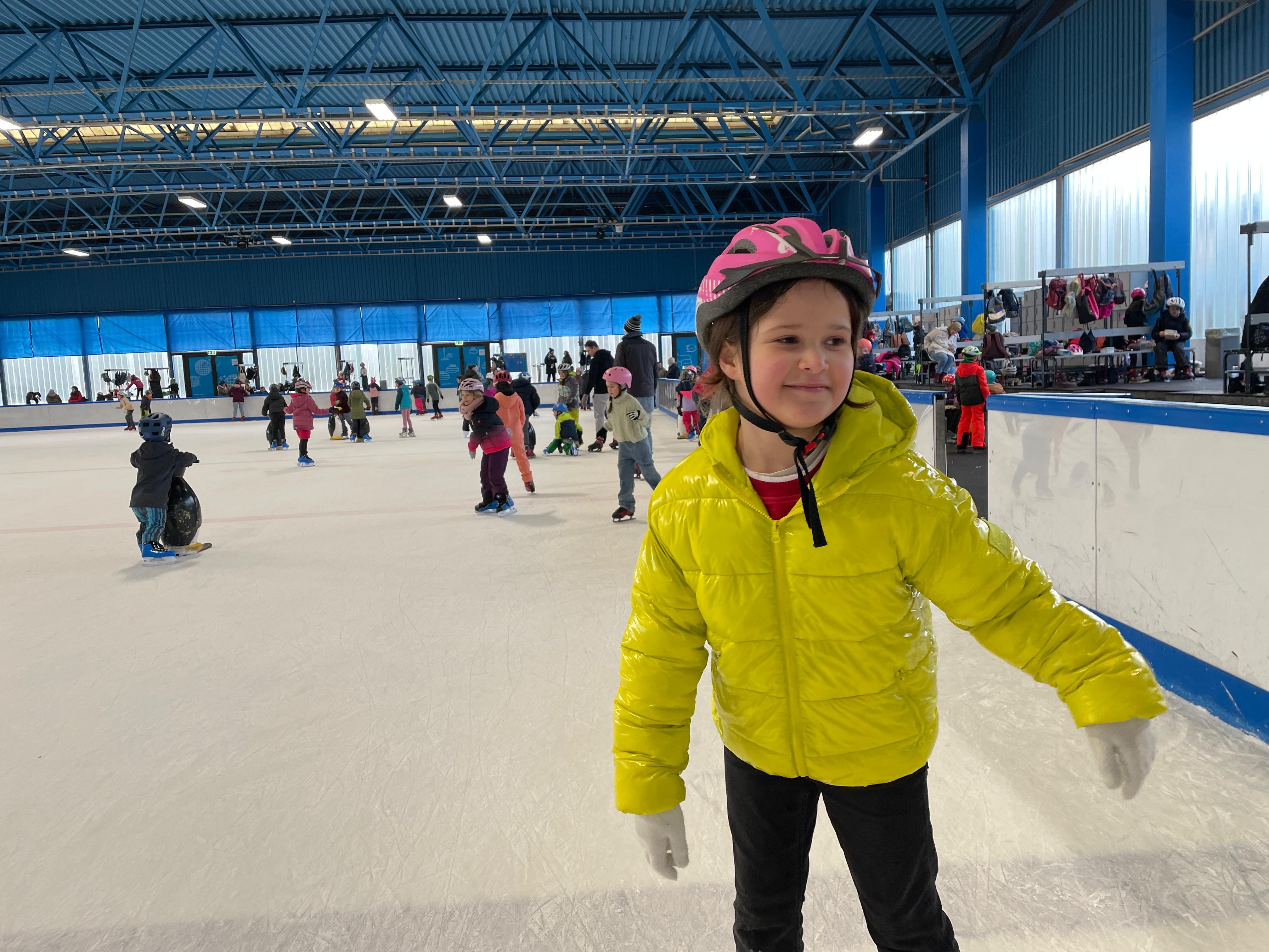 Bildbeschreibung: Kinder fahren Schlittschuh auf einer Eisfl&auml;che.