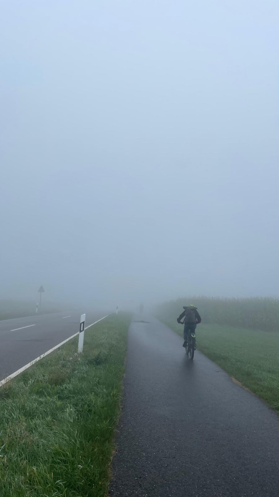 Ein Sch&uuml;ler f&auml;hrt Fahrrad im Spr&uuml;hregen