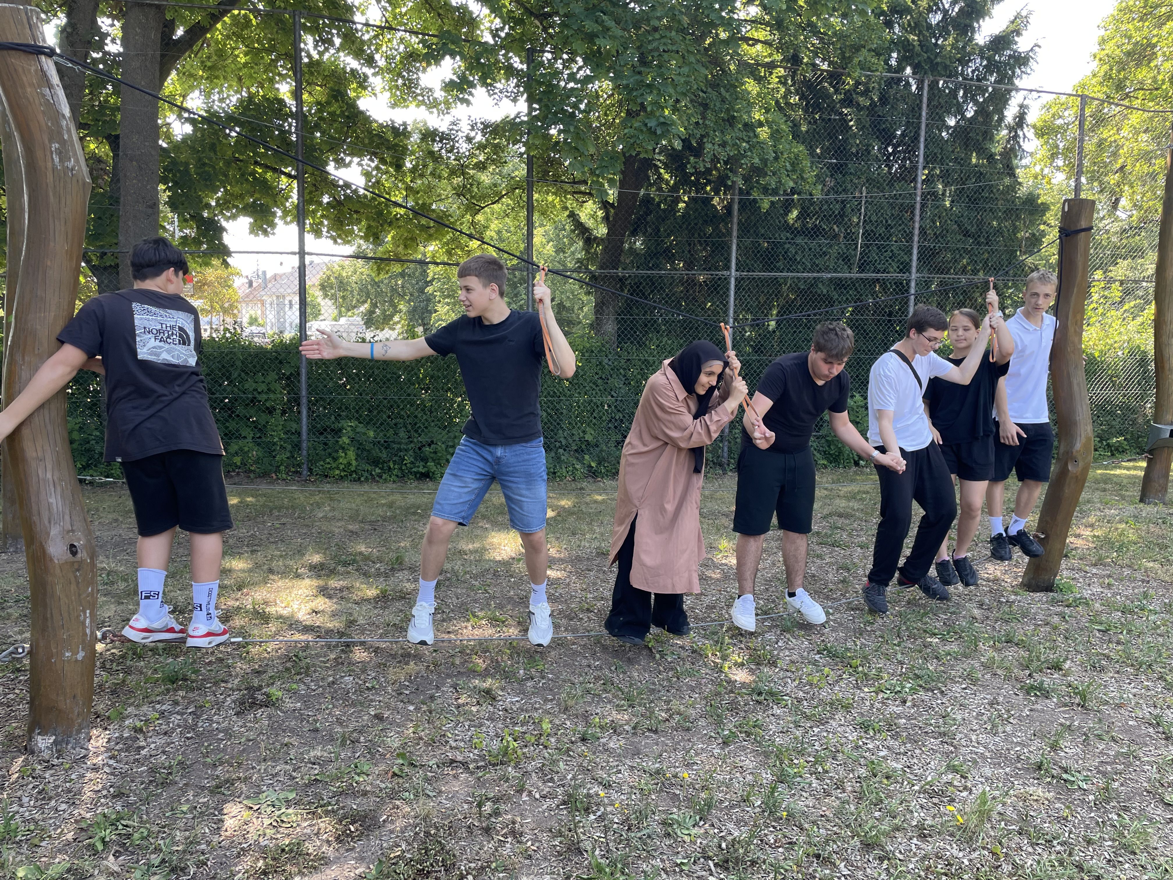 Schülerinnen und Schüler gemeinsam auf einer Slackline