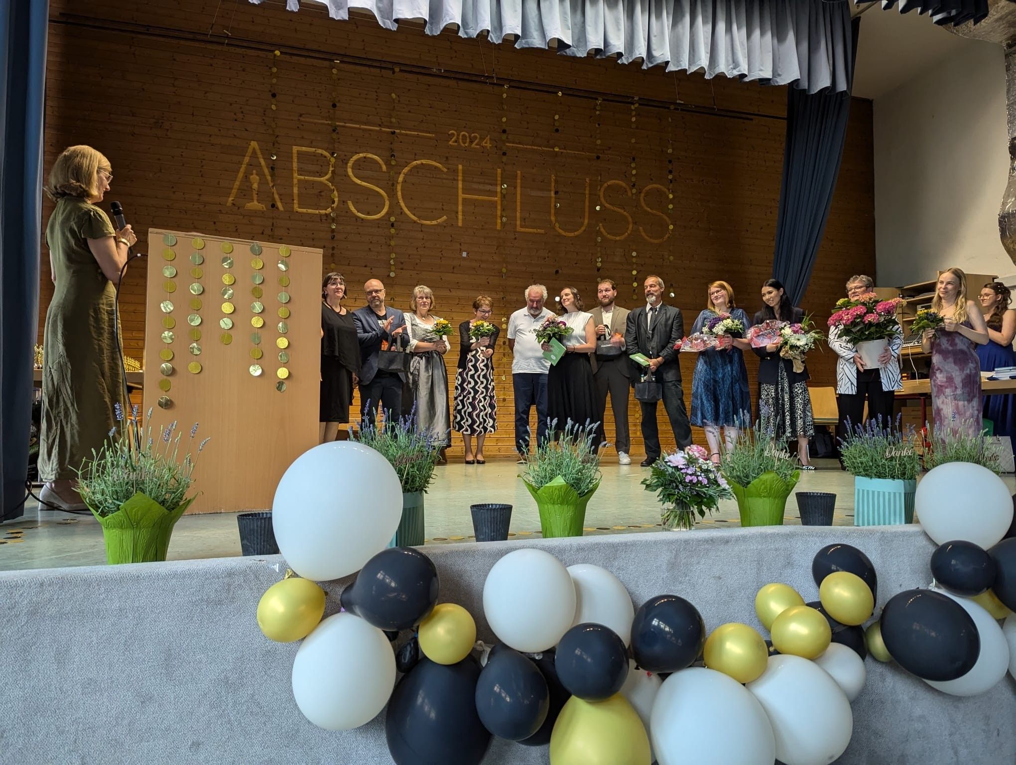 Dankesworte an die Lehrkräfte vor einer dekorierten Bühne