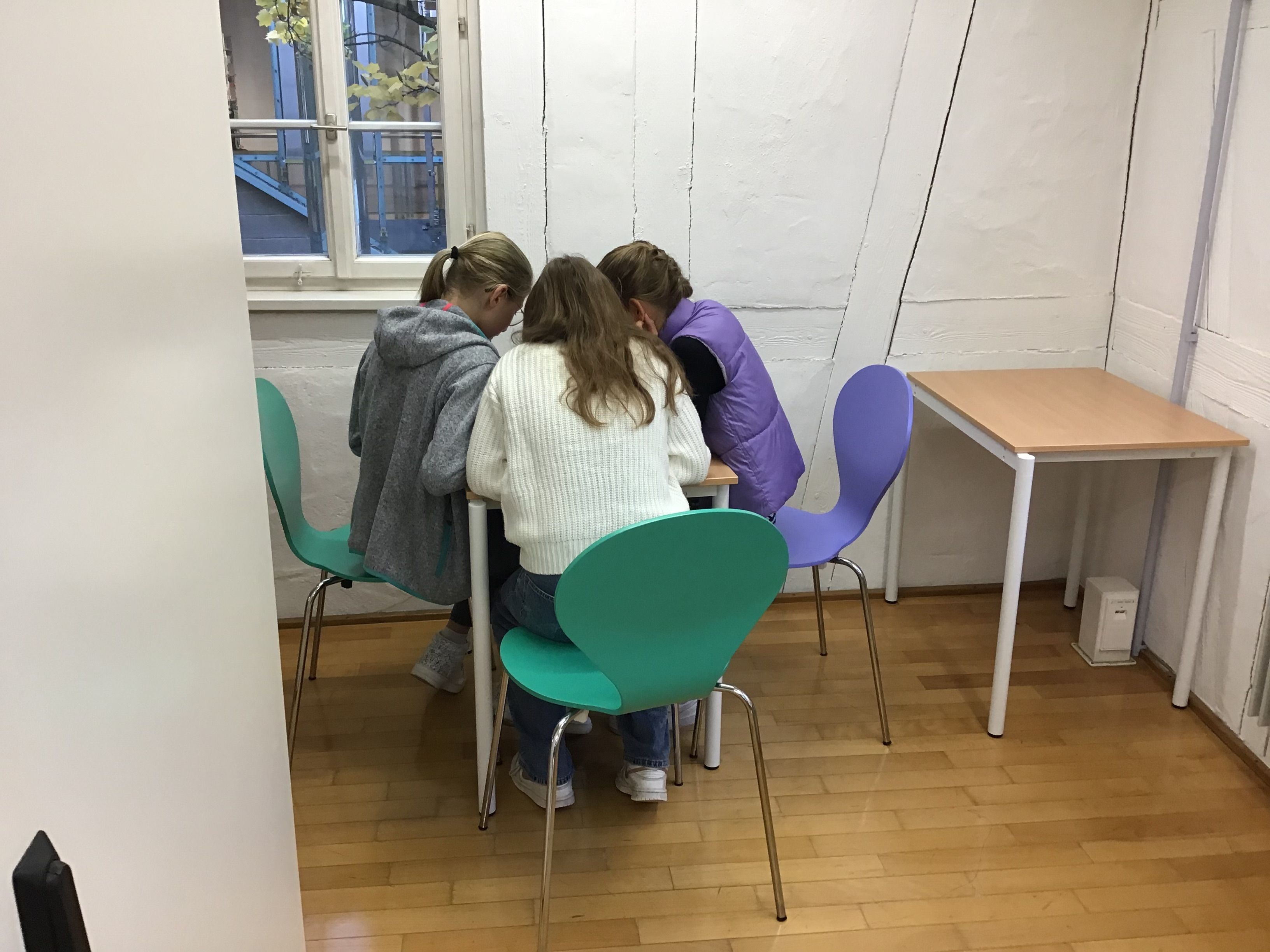 Eine Mädchengruppe sitzt vor dem iPad und prüft Apps