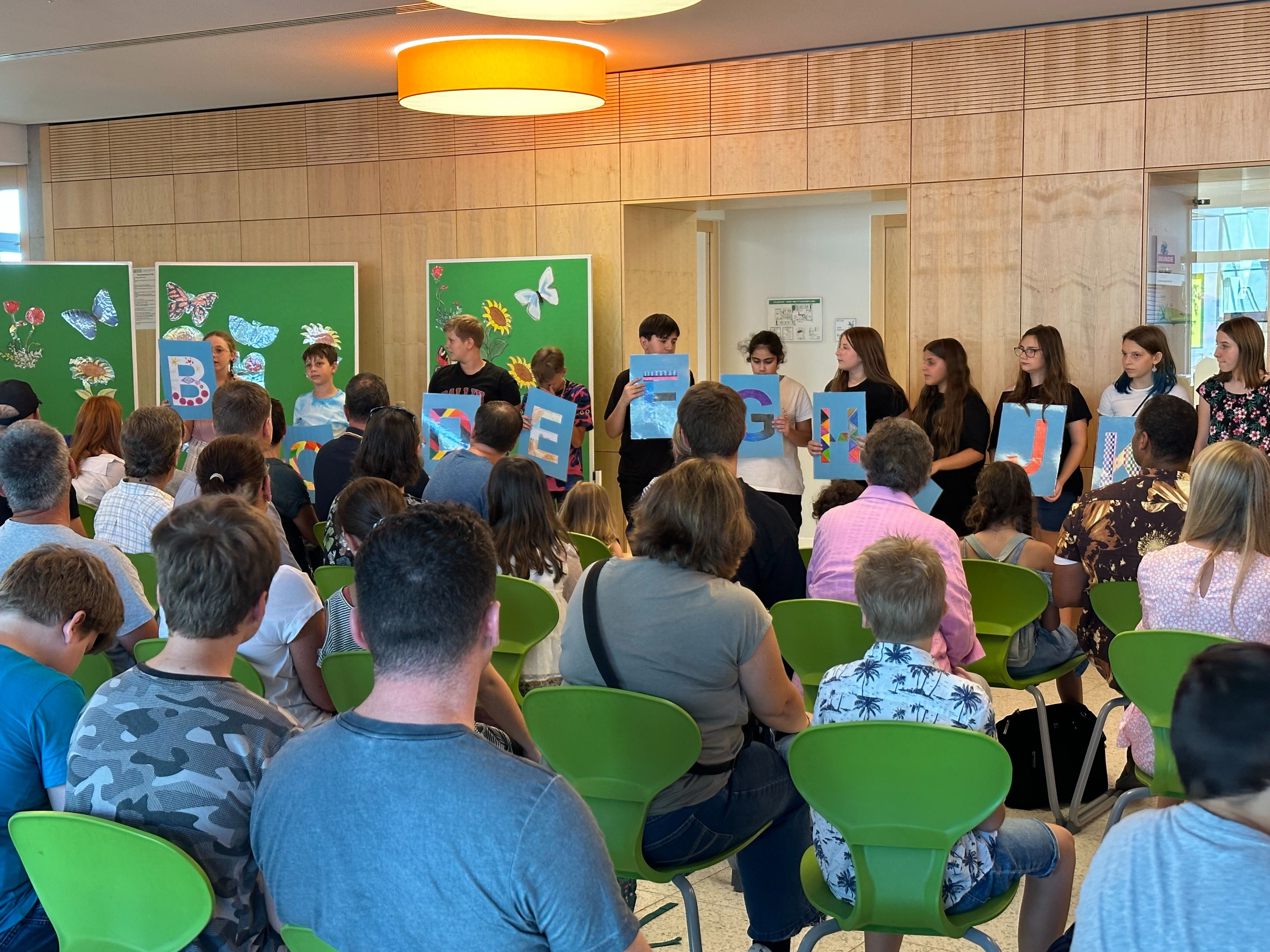 Die Eltern sehen die Darbietung der Stufe 6 in der Aula